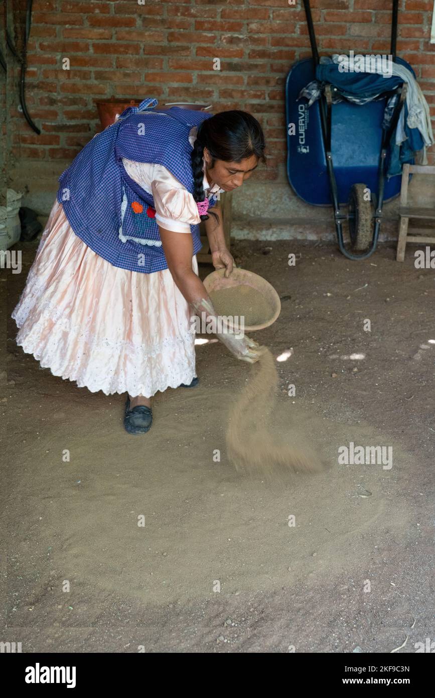 Making red clay pottery. Potter mixing red dirt with the clay for color