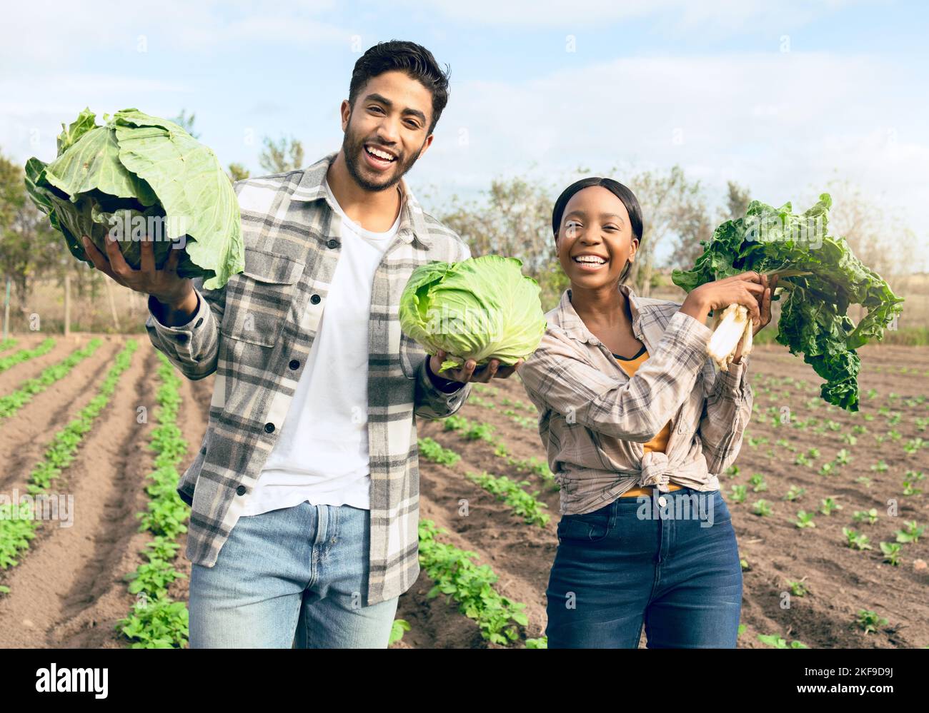Farming, harvest and interracial couple with vegetables from their sustainable, agro and agriculture farm. Sustainability, small business and portrait Stock Photo