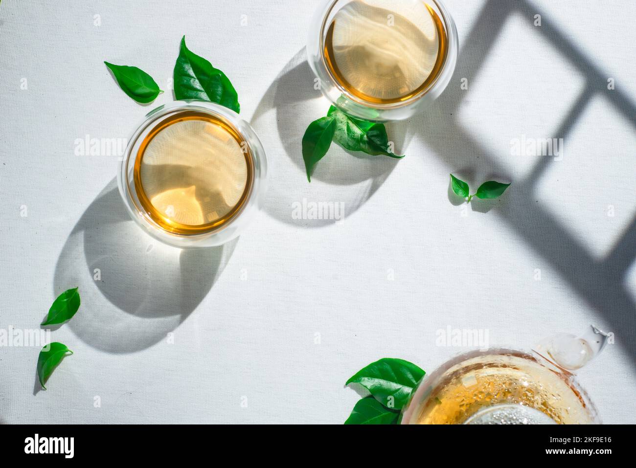 Impecable tablecloth, white linen with glass teapot and tea leaves Stock Photo