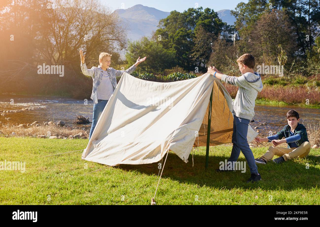 On a camping adventure with the guys. a group of young boys putting up