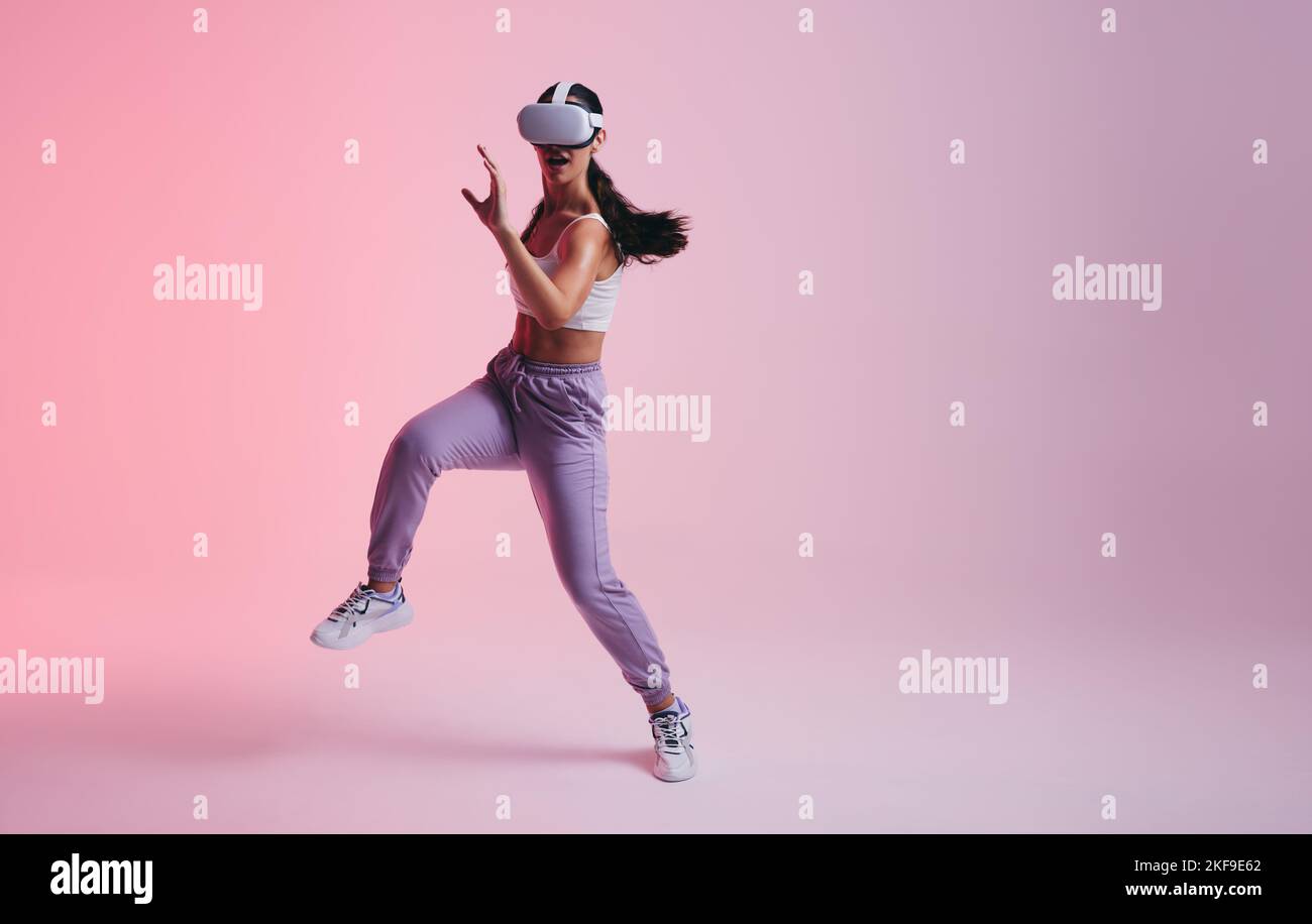 Dance moves in the metaverse. Active young woman dancing while wearing ...