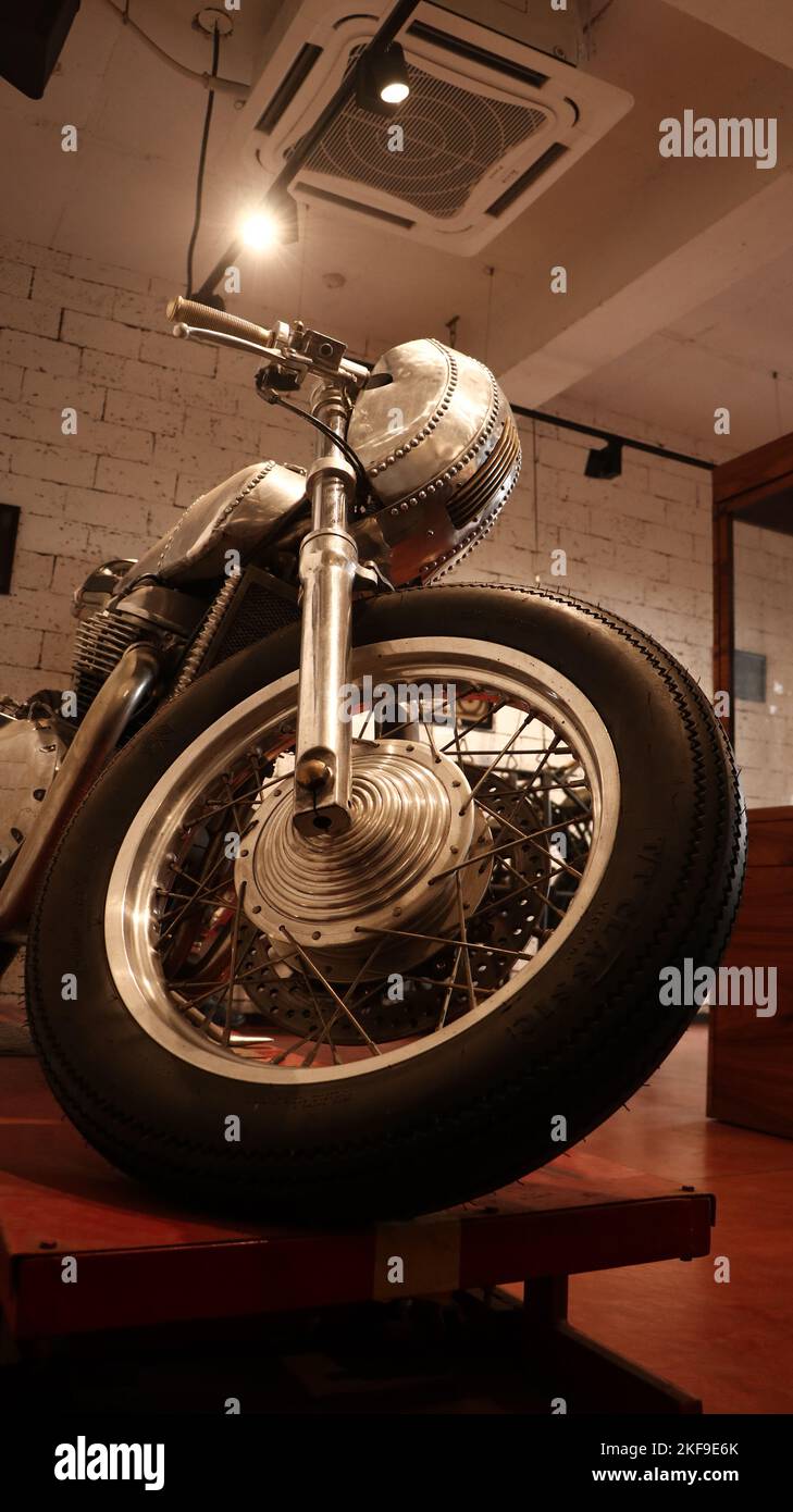a restored old retro motorcycle kept on display in a coffee shop for attracting customers and enthusiasts. Stock Photo