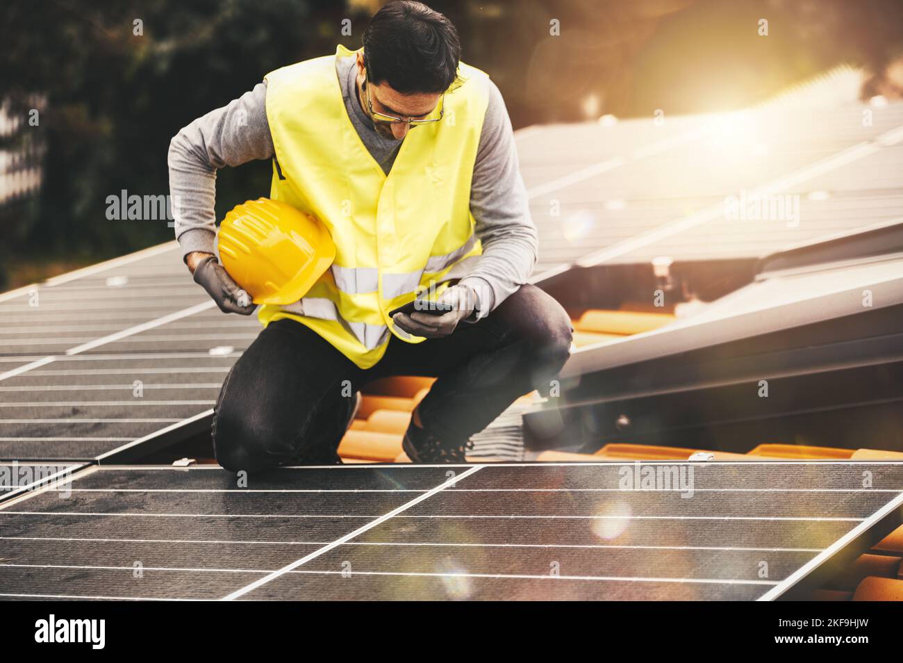 Workers verify energy system with solar panel with a phone Stock Photo