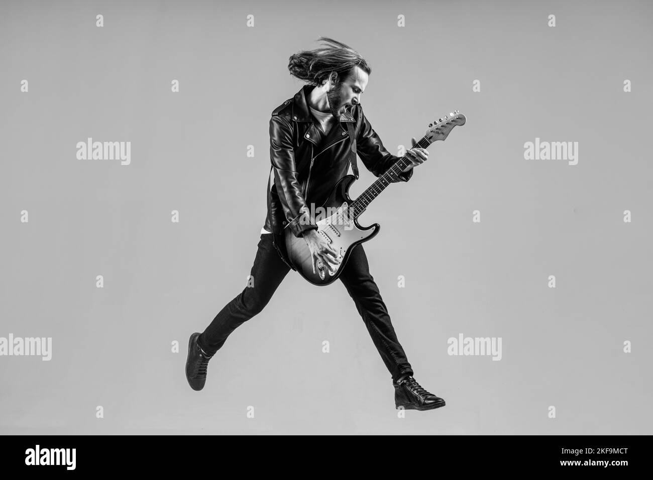 stylish crazy man. musical instrument. emotional bearded rocker in leather jacket. Stock Photo