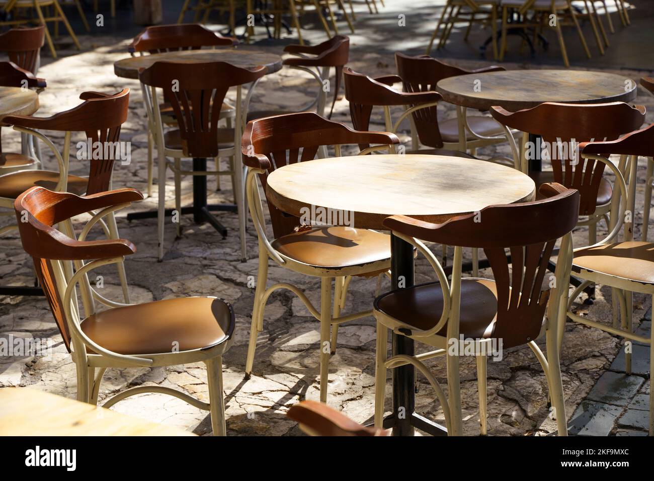 Street cafe in summer with wooden vintage chairs and tables on a tourist street. Empty restaurant or cafe without visitors. High quality photo Stock Photo