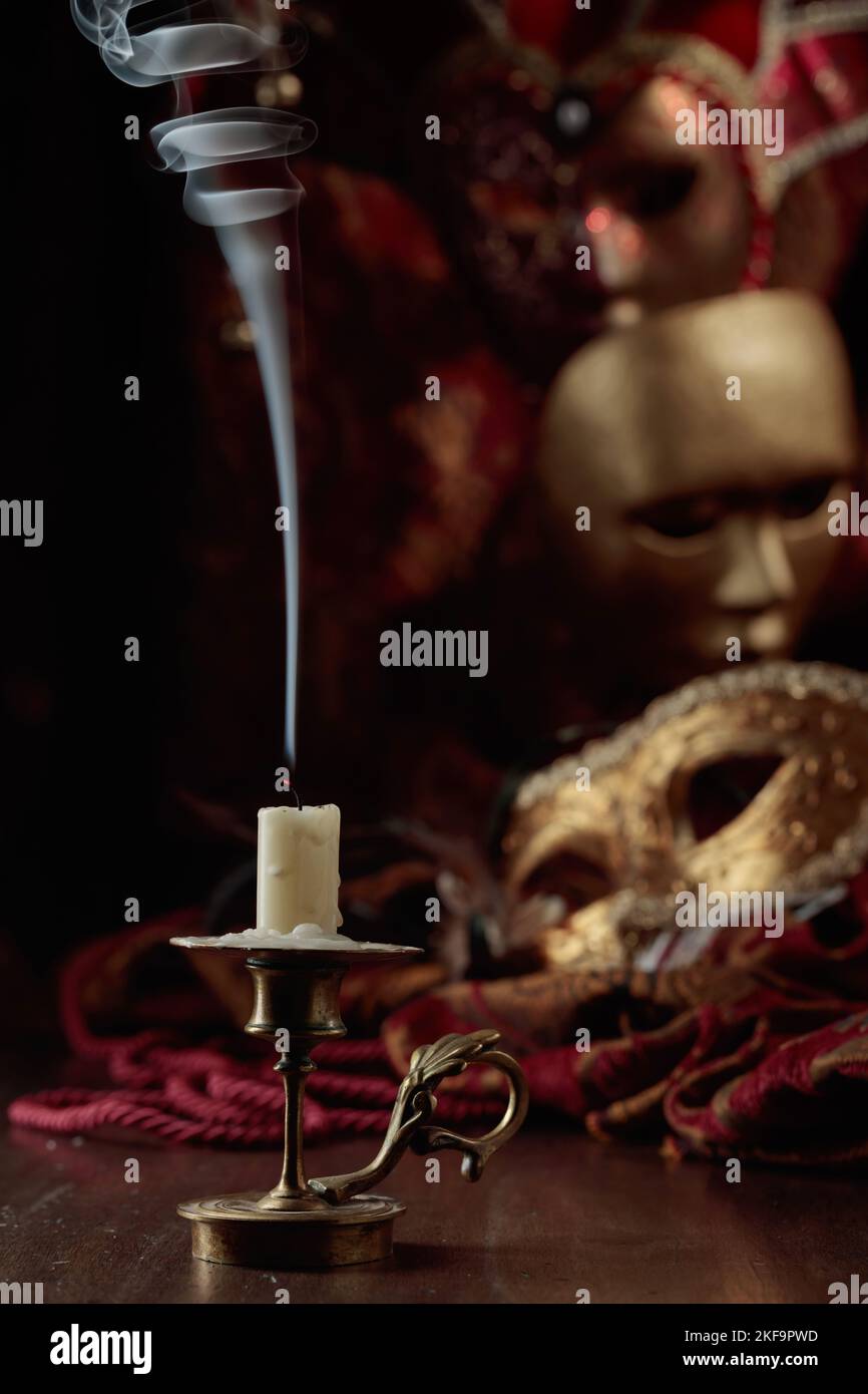 Still life with an extinguished candle in an old brass candlestick and