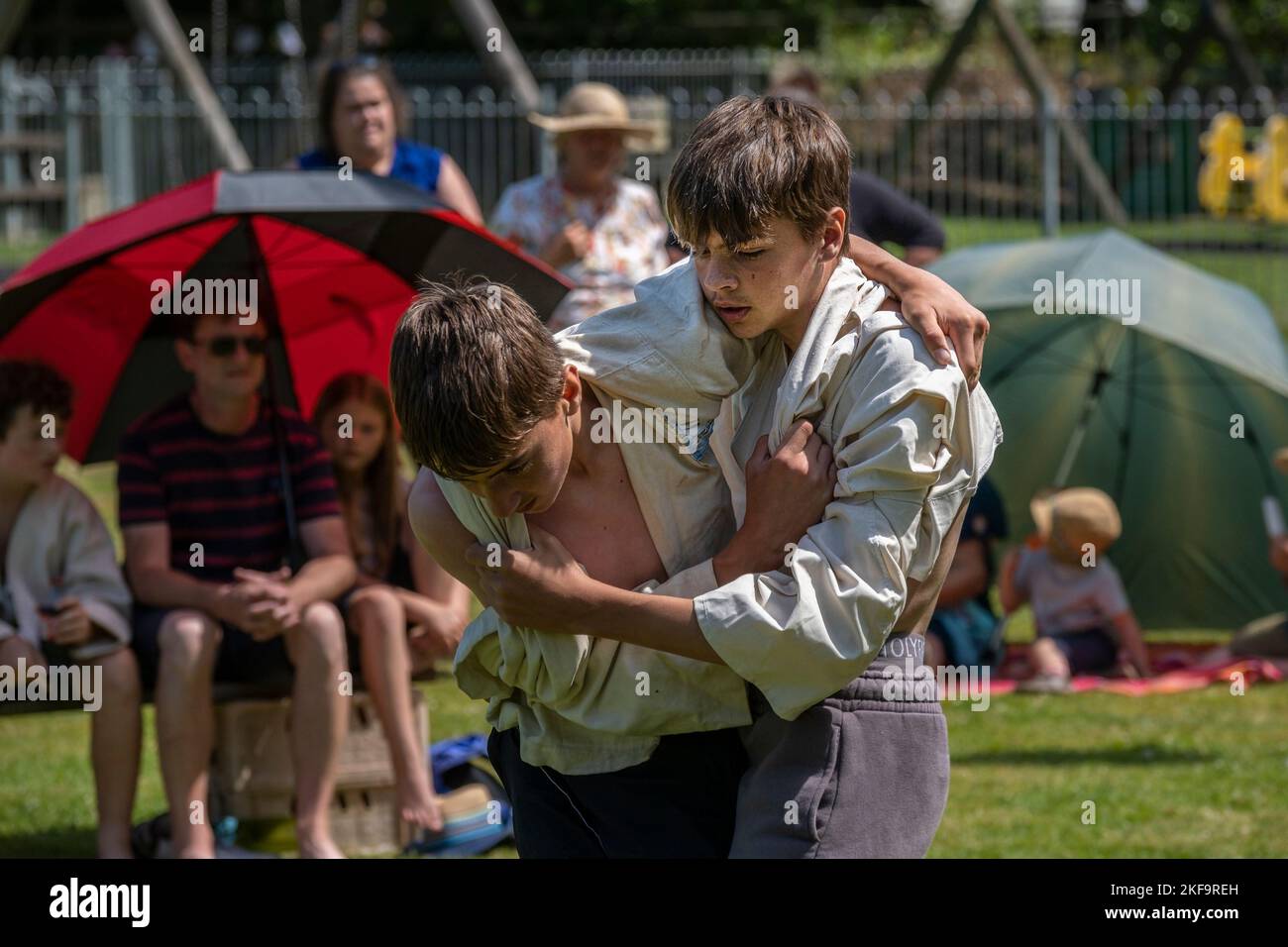 Two young teenagers brothers competing in the Grand Cornish Wrestling Tournament on the picturesque village green of St Mawgan in Pydar in Cornwall in Stock Photo