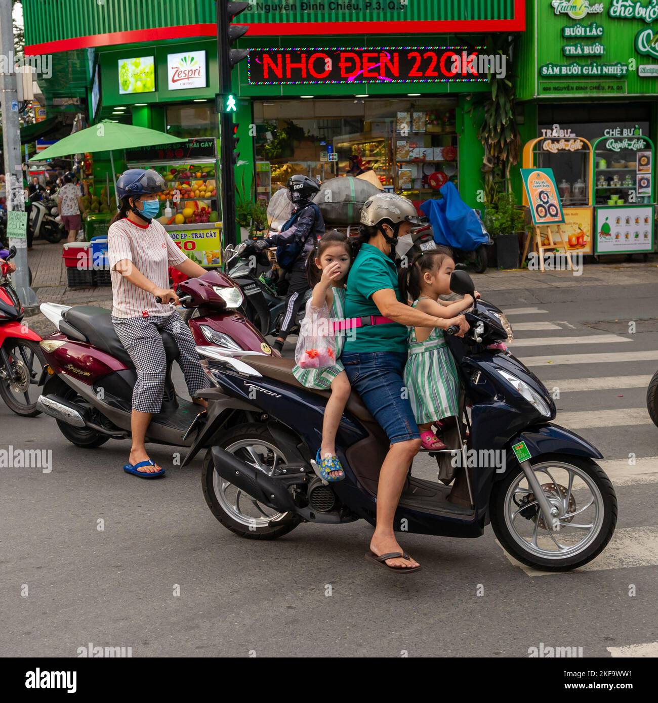 Saigon Street Life.  A mother with her two children on a motorcycle in Ho Chi Minh City Stock Photo