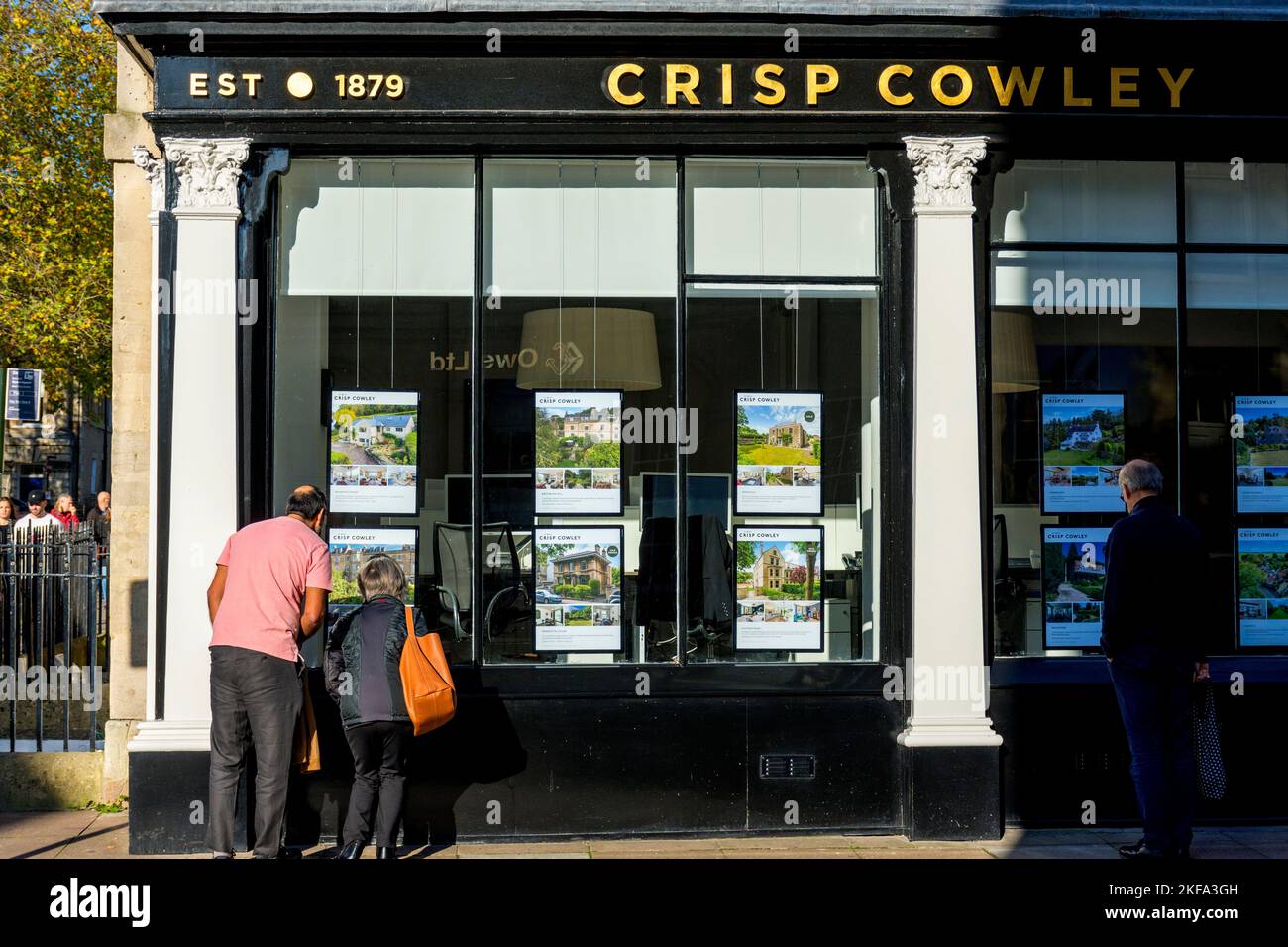 People looking into the window of an estate agents office in Bath, Somerset, England, UK Stock