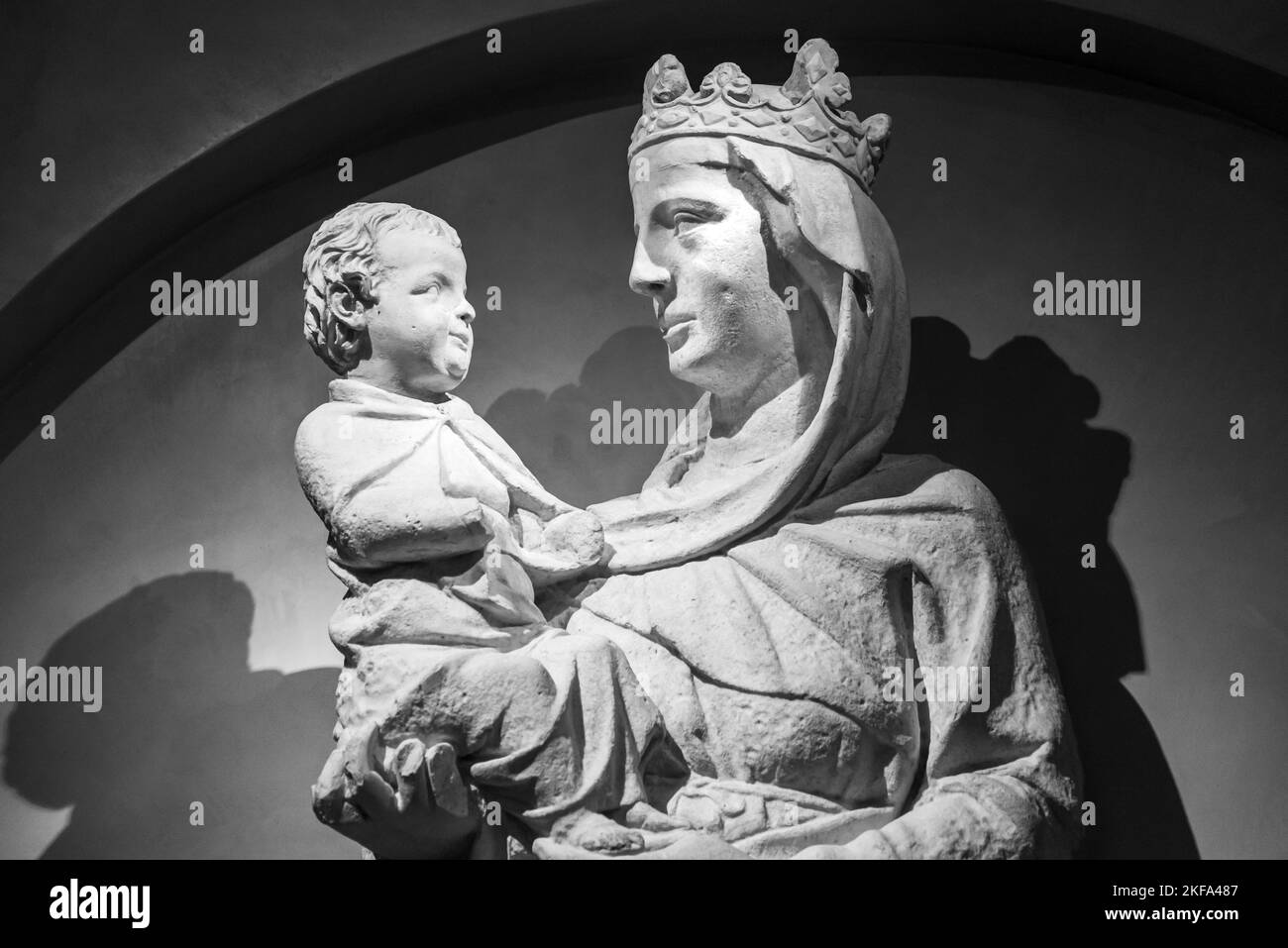 Black and white photo of stone statues representing a crowned Virgin Mary holding baby Jesus in her arms Stock Photo