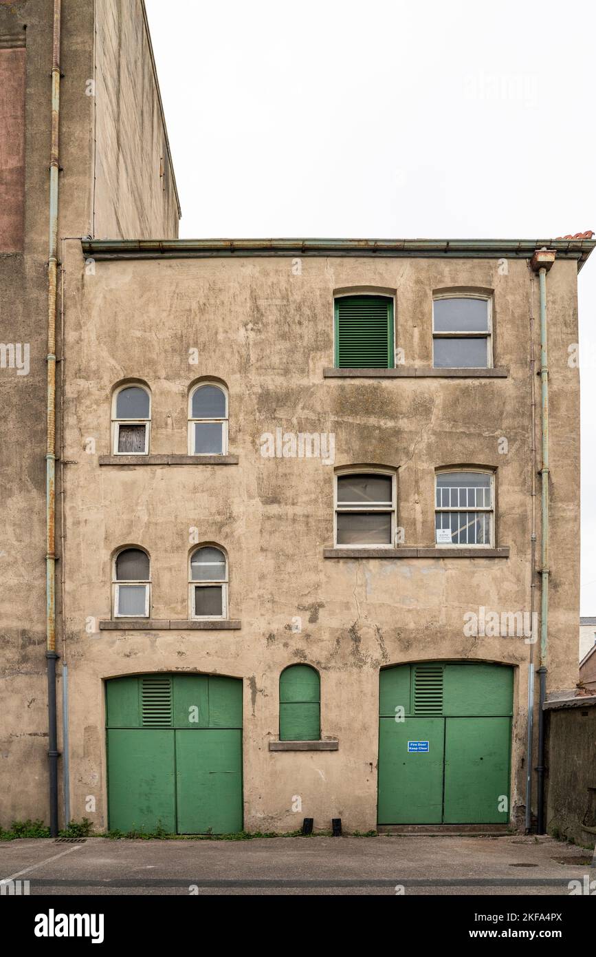 Green doors to small commercial warehouse in town Stock Photo