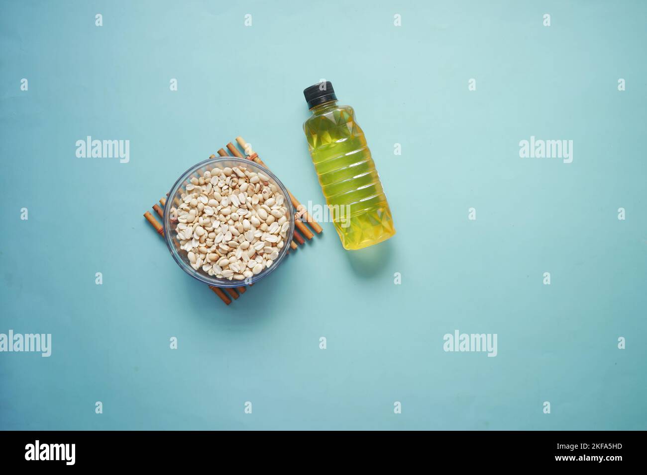 peanuts and oil in container on color background Stock Photo Alamy