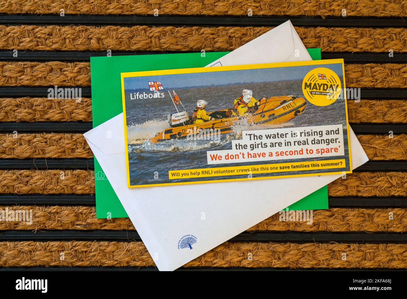 Post mail on doormat - charity appeal, RNLI Lifeboats Mayday an RNLI appeal Will you help RNLI volunteer crews like this one save families this summer Stock Photo