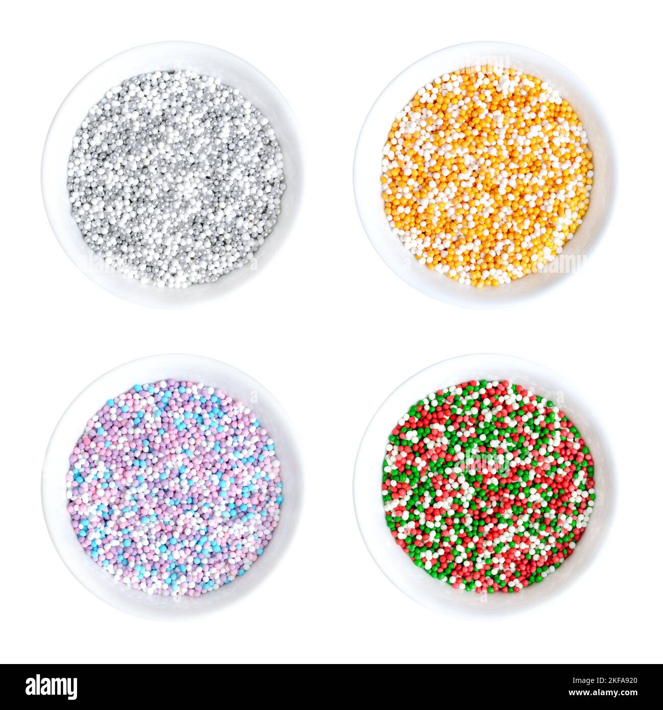 Colored nonpareils in white bowls. Four colored mixes of decorative and edible confectionery of tiny balls. Hundreds and Thousands. Stock Photo