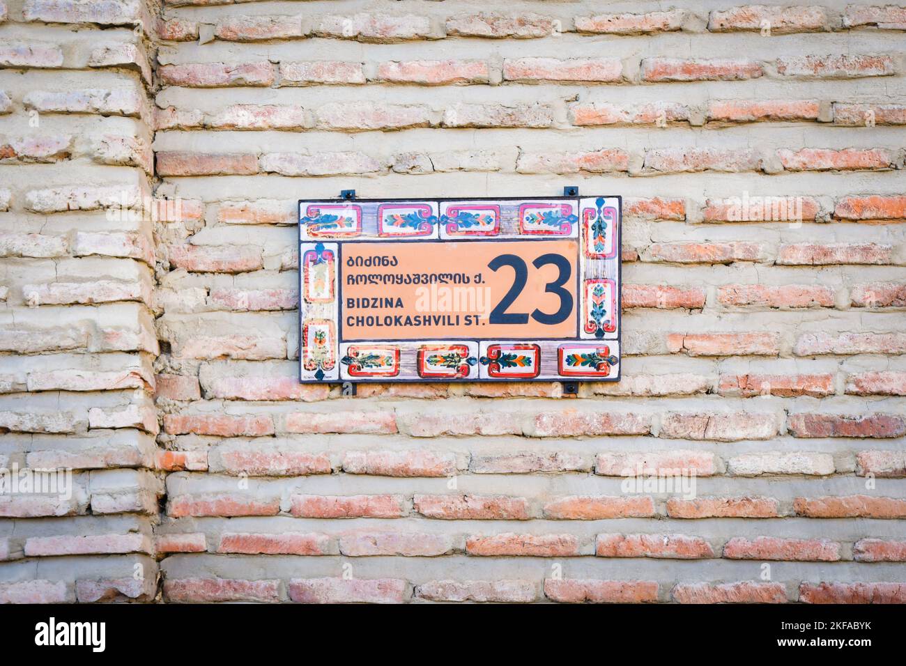 Brick Wall With Stylish Ornamental House Number And Street Name Sign In Brick Wall With Stylish Ornamental House Number And Street Name Sign In