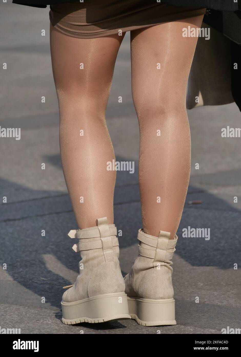 Girl in miniskirt, mini boots and tan pantyhose in Duomo square, Milan, Lombardy, Italy Stock Photo
