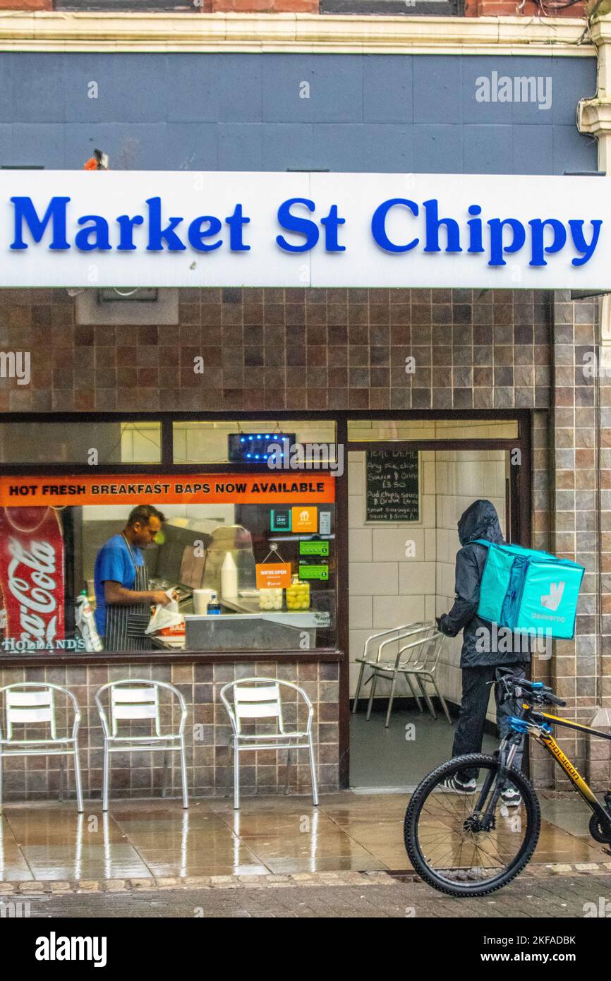 Deliveroo rider collecting order from Market Street Chippy in Preston