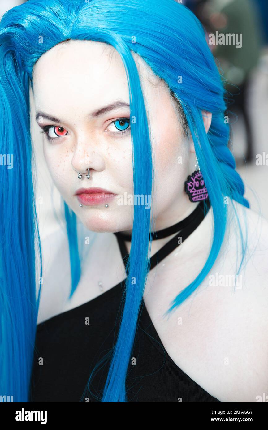 Close up portrait of a gender fluid or non binary teenager with colourful contact lenses and nose and lip piercings Stock Photo