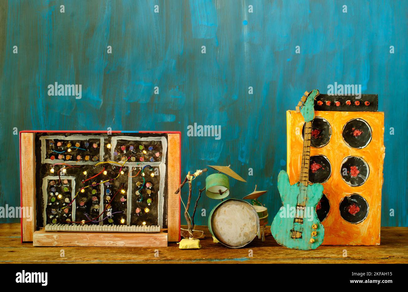 Grungy cardboard models of synthesizer,drum kit,guitar,amplifier and microphone on stage,music,performance,instruments concept,free copy space Stock Photo
