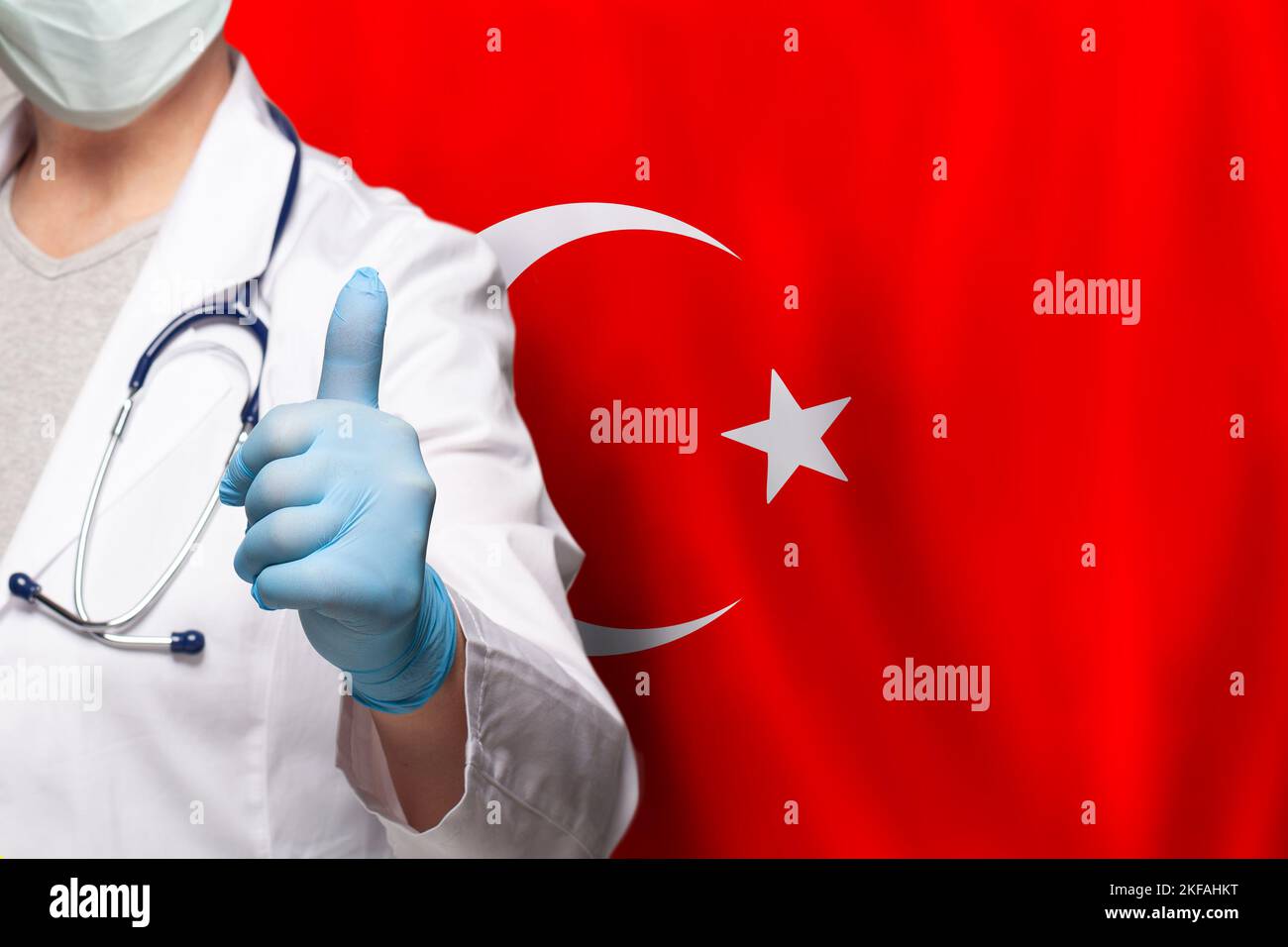 Turkish doctor's hand showing thumb up positive gesture on flag of