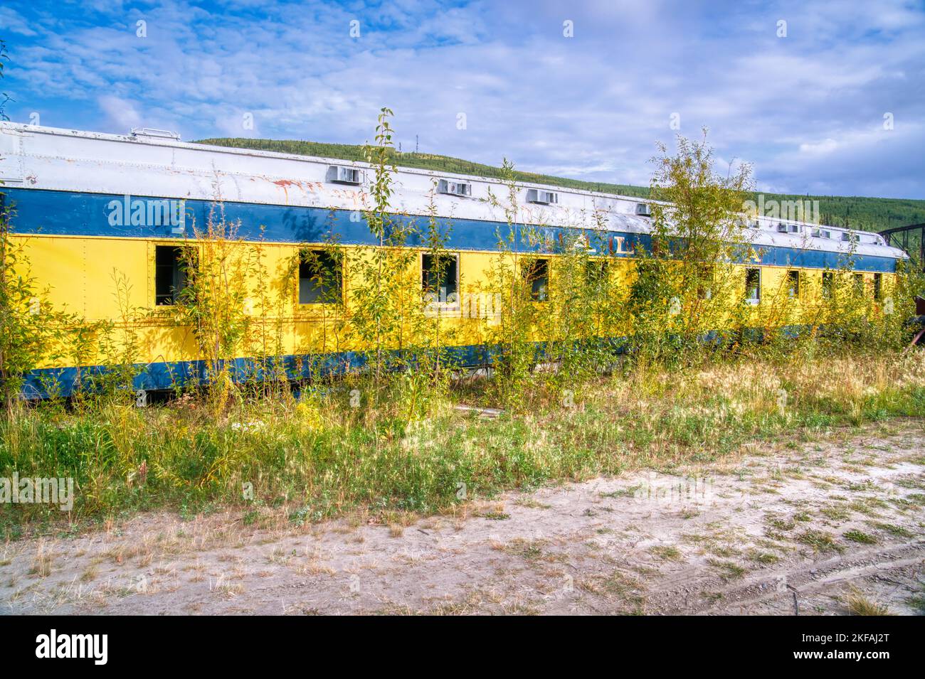 Abandoned and overgrown old railroad passenger car in Alaska Stock Photo