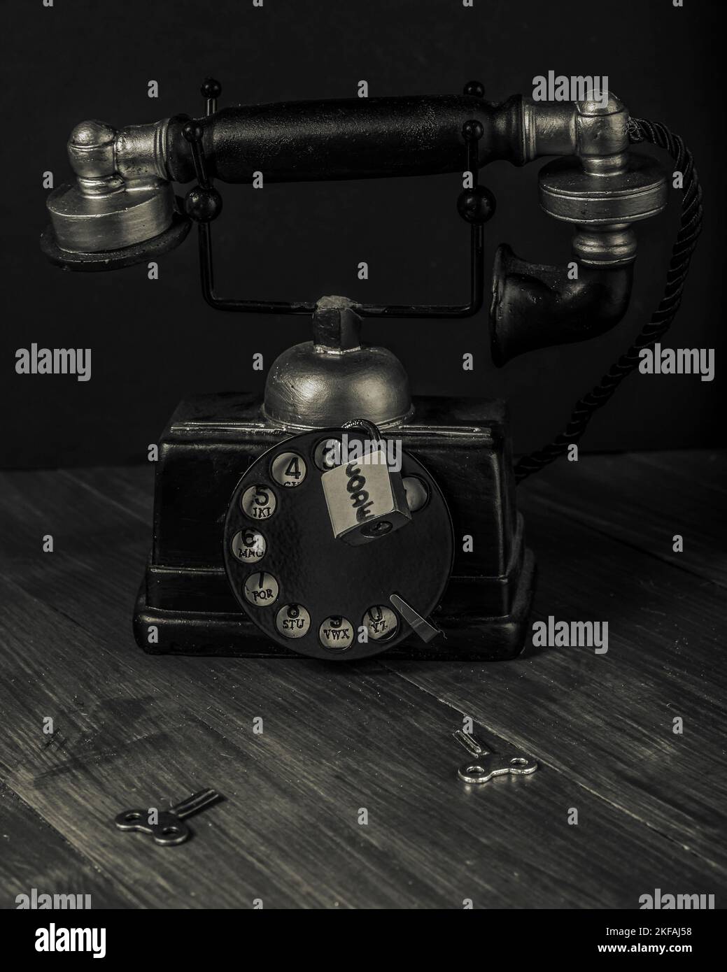 An antique vintage manual telephone is locked by a padlock marked code Stock Photo