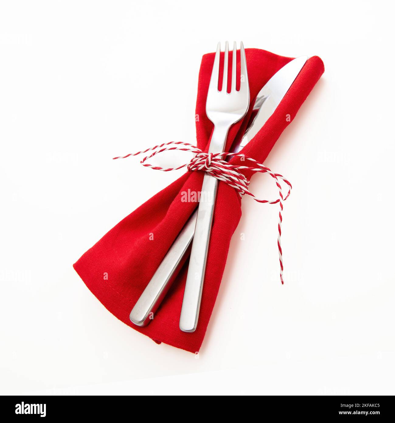 Holiday table setting, celebration dinner. Cutlery, red cloth napkin