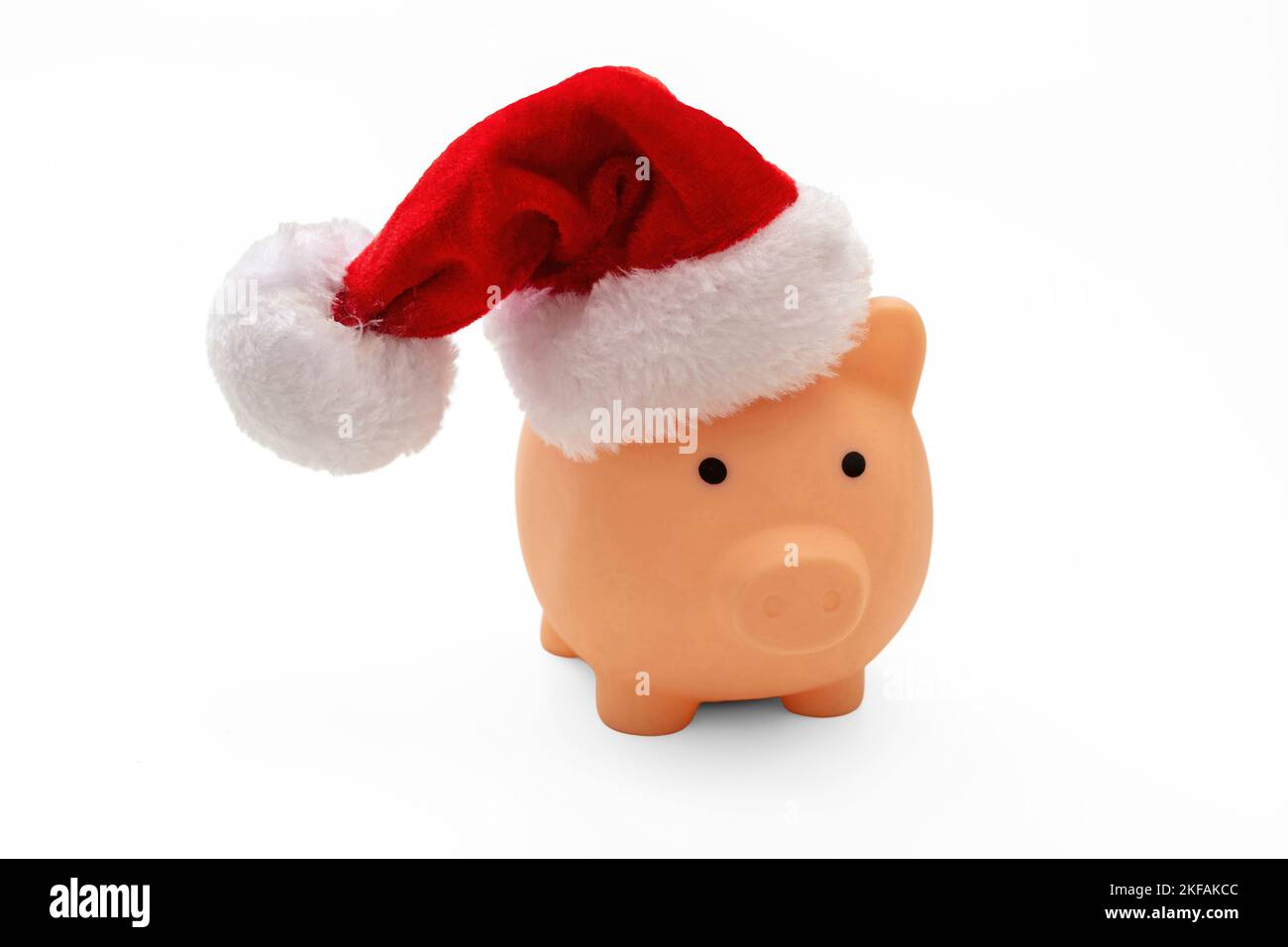Christmas holiday cost and savings. Piggy bank with Santa hat isolated on white background. Stock Photo