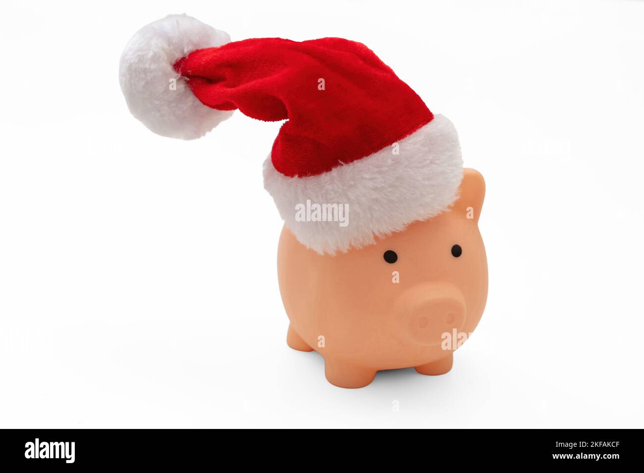 Christmas holiday bonus and expenses. Piggy bank with Santa hat isolated on white background. Stock Photo