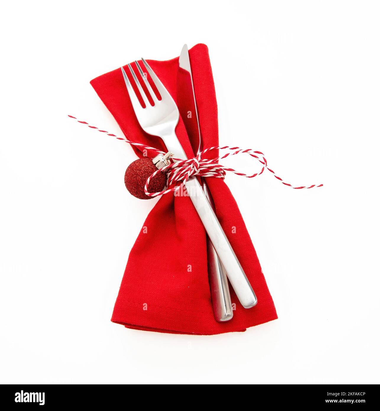 Christmas Holiday table setting, celebration dinner. Cutlery, red cloth napkin and twine string bow isolated on white, Stock Photo