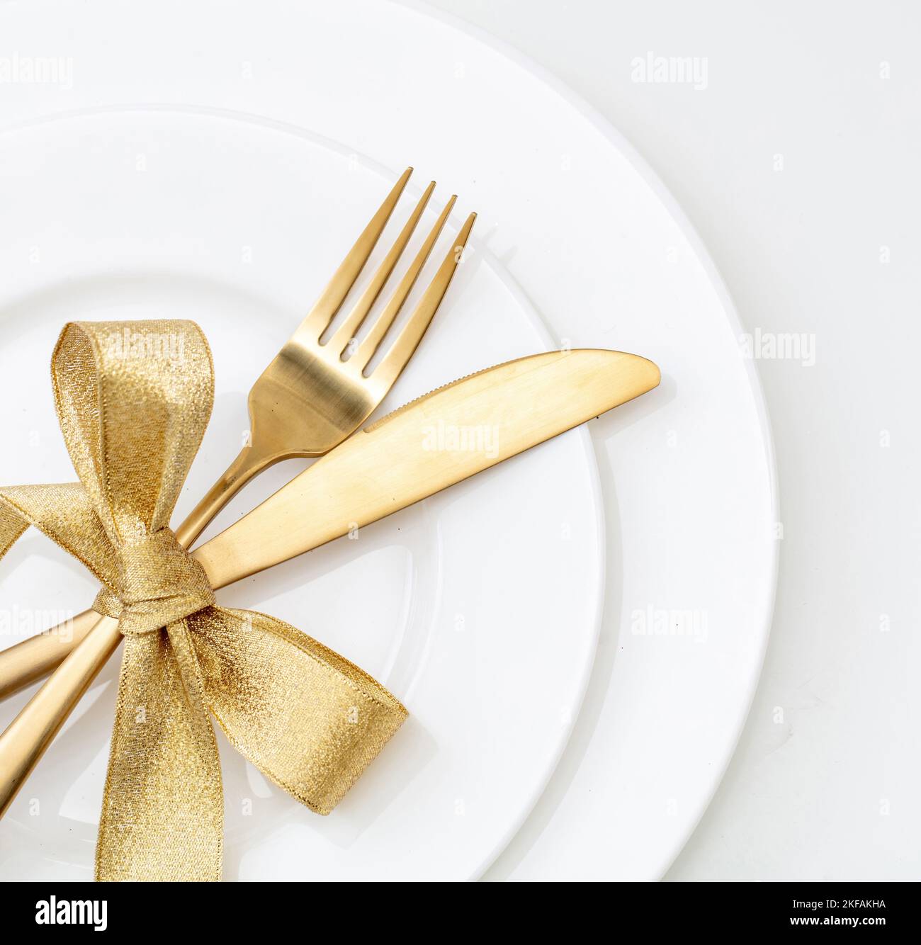 Christmas table setting top view. Gold cutlery and decoration on white dishes, Elegant restaurant, celebration dinner Stock Photo