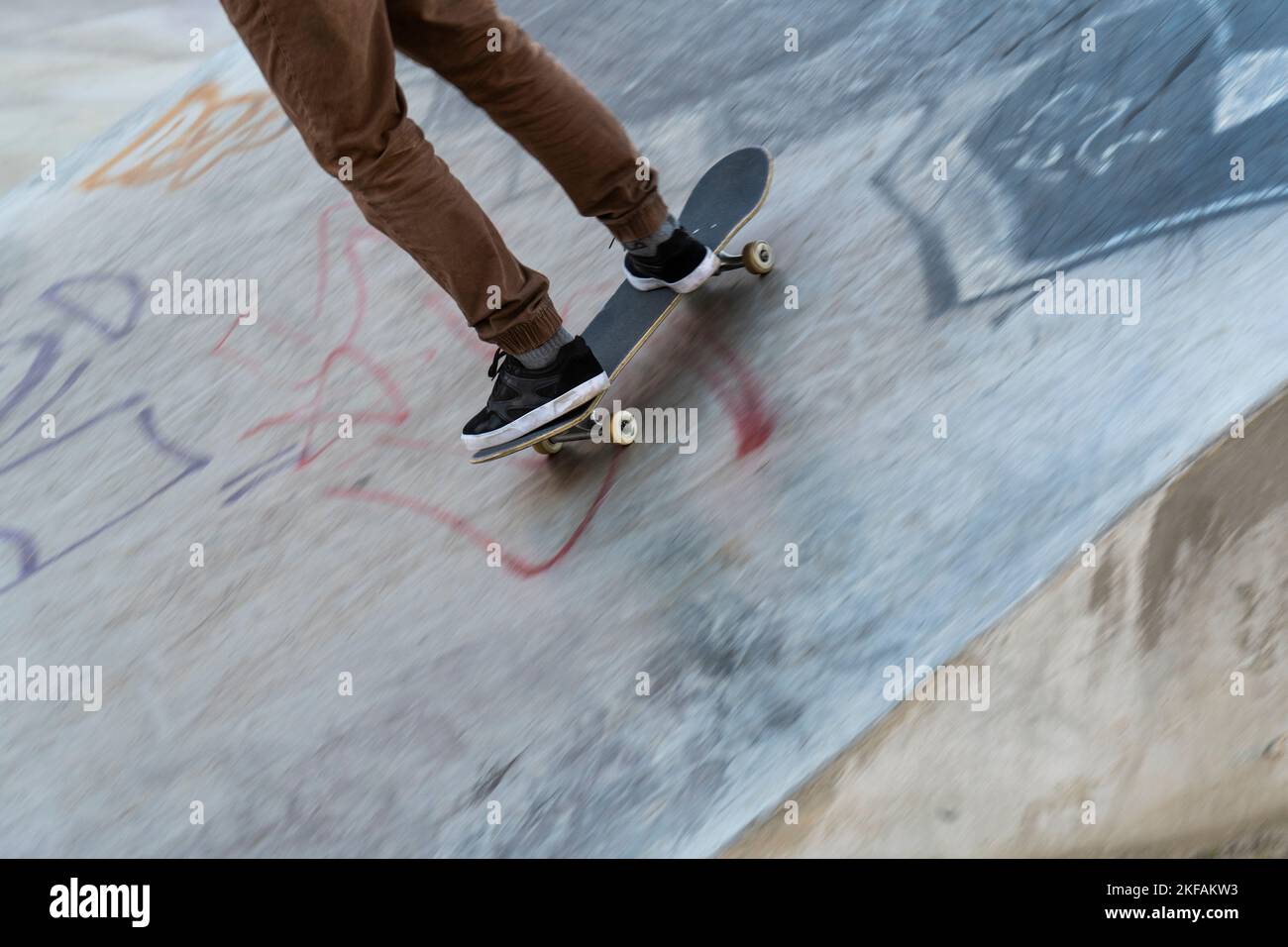 Selective cropping of a young skater practicing at a skate park. Stock Photo
