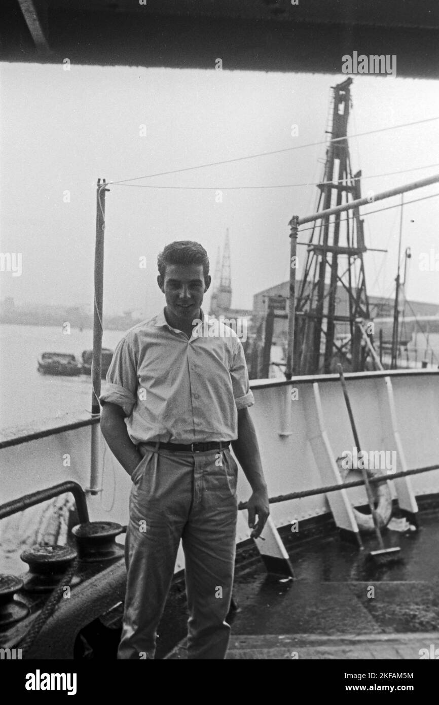 Junger Mann raucht an Bord eines Schiffes im Hamburger Hafen, 1959. Young man smoking on board of a ship in the port of Hamburg, 1959. Stock Photo