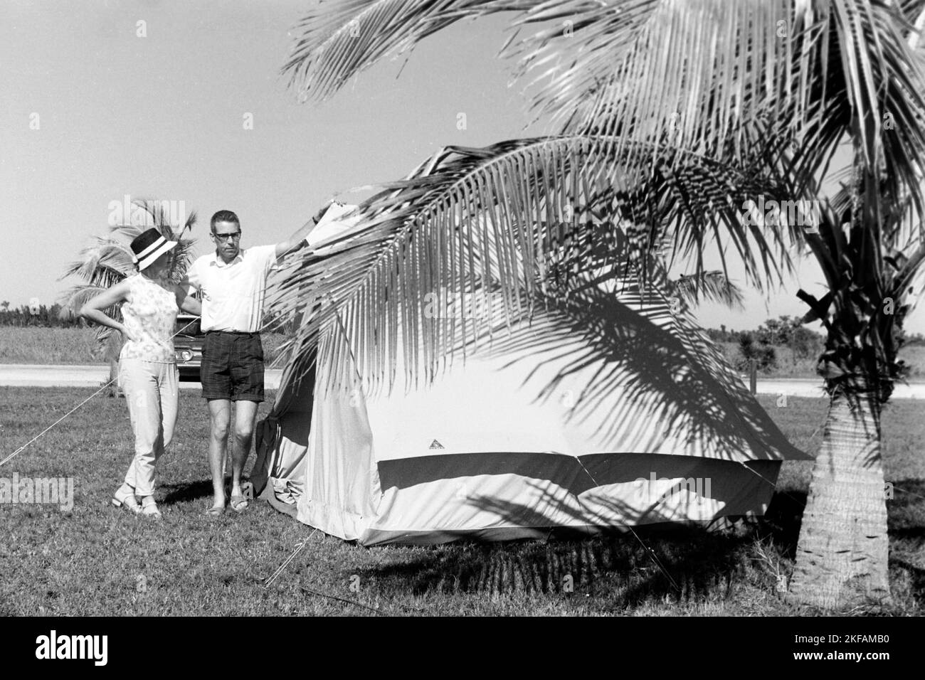 Paar posiert vor erfolgreich aufgebautem Zelt im Oleta River State Park, Miami, Florida, USA 1965. Couple posing in front of successfully erected tent at Oleta River State Park, Miami, Florida, USA 1965. Stock Photo