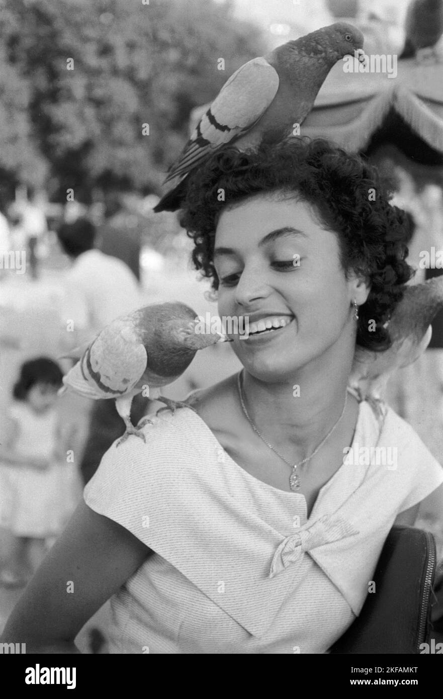 Eine lachende Frau hat spaß mit Tauben, Barcelona Spanien um 1950. A laughing woman has fun with pigeons, Barcelona Spain around 1950. Stock Photo