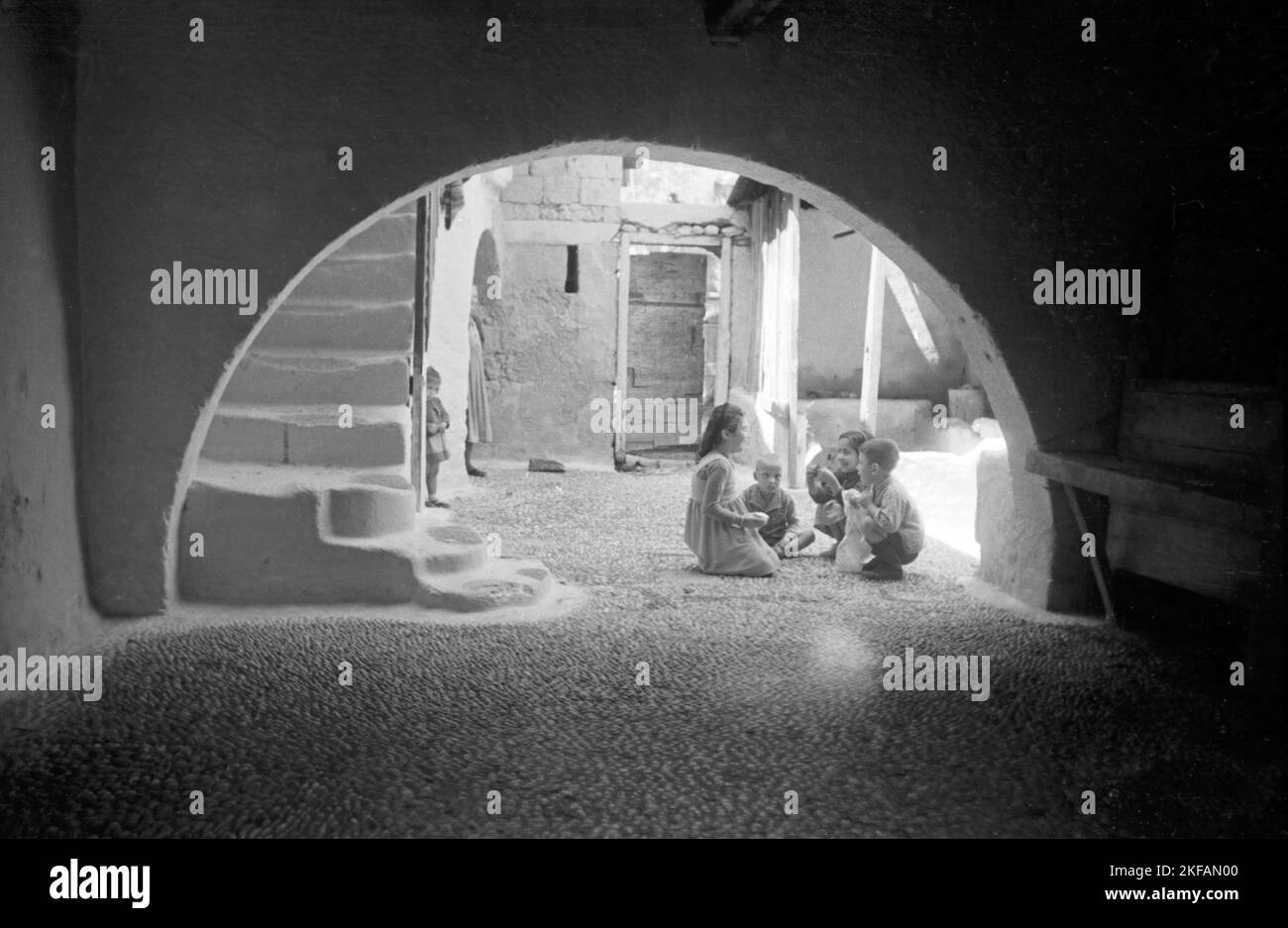 Kinder spielen im Hof, von einer Unterführung aus gesehen, Griechenland, 1950er Jahre. Children playing in a courtyard, seen from an archway, Greece, 1950s. Stock Photo