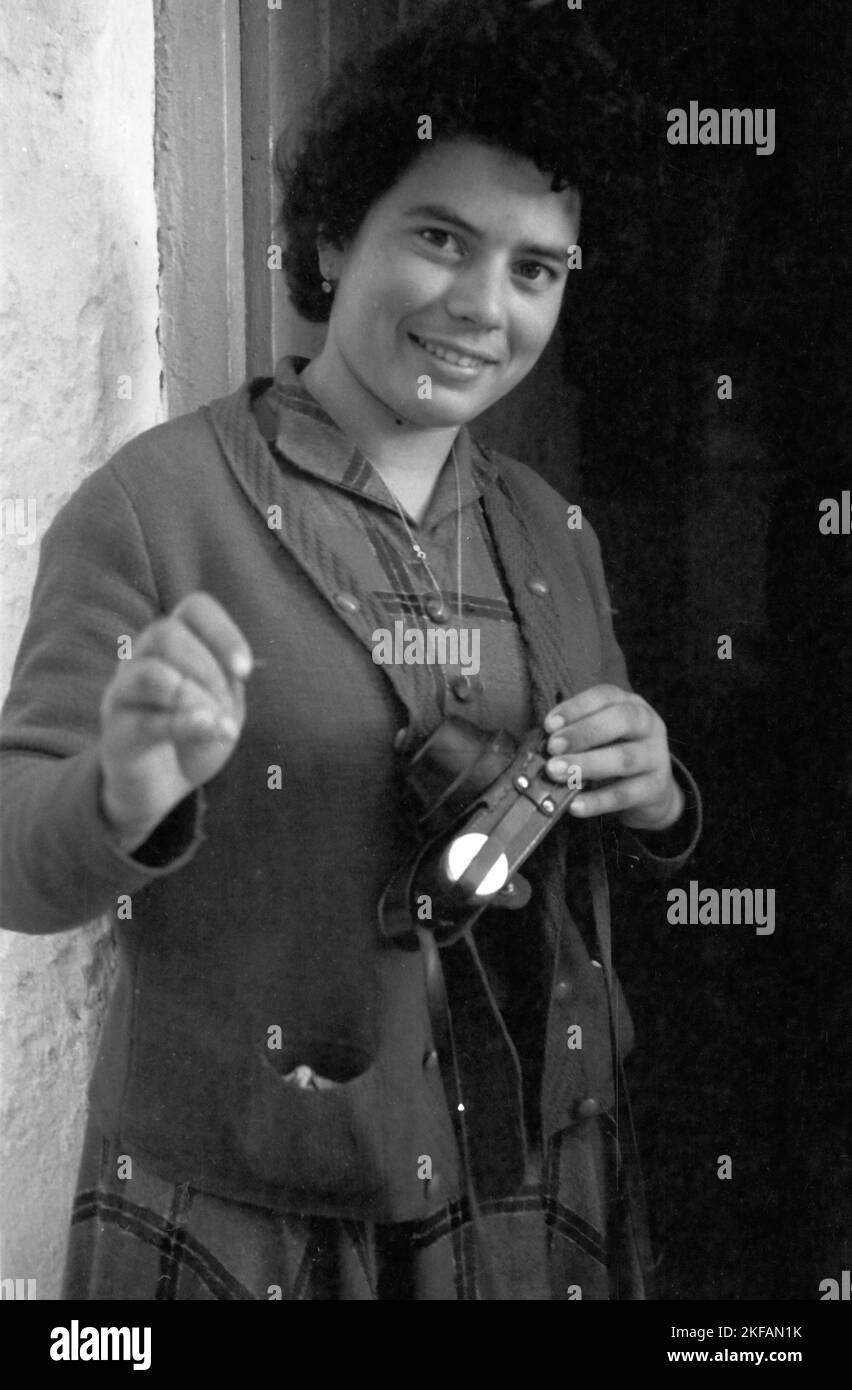 Eine Schneiderin erneuert eine Naht an der Kameratasche des Fotografen, Griechenland 1950er Jahre. A taylor woman renewing the camera pocket of the photographer, Greece, 1950s. Stock Photo