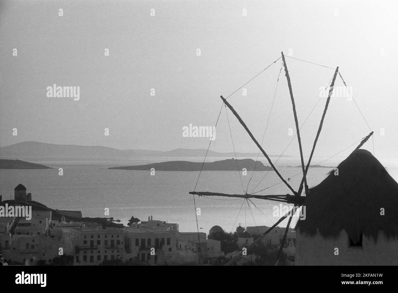 Die Silhouette eines Dorfes und einer Windmühle im Sonnenuntergang, Griechenland 1950er Jahre. The shadow of a village and a windmill in the sunset in Greece, 1950s. Stock Photo