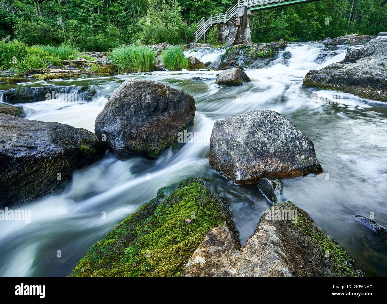 Big rocks in river. Bridge and waterfall Stock Photo - Alamy