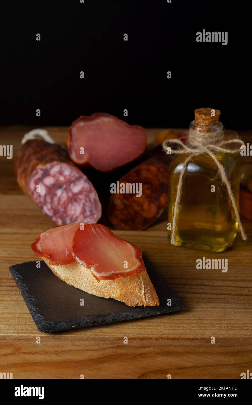 tapa of iberian loin on rustic bread with olive oil on a black slate ...