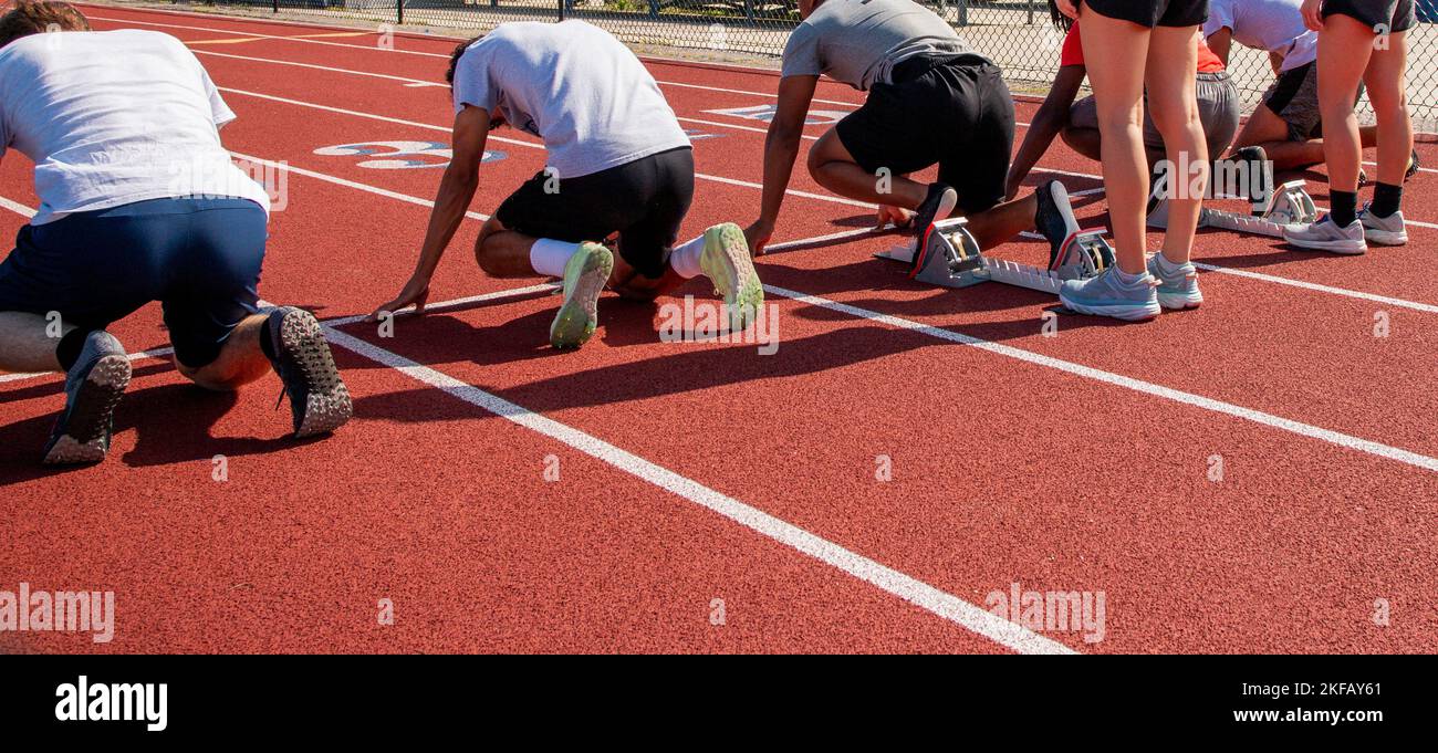 Reat view of high school sprint runners in the on your mark position ready to race each other in