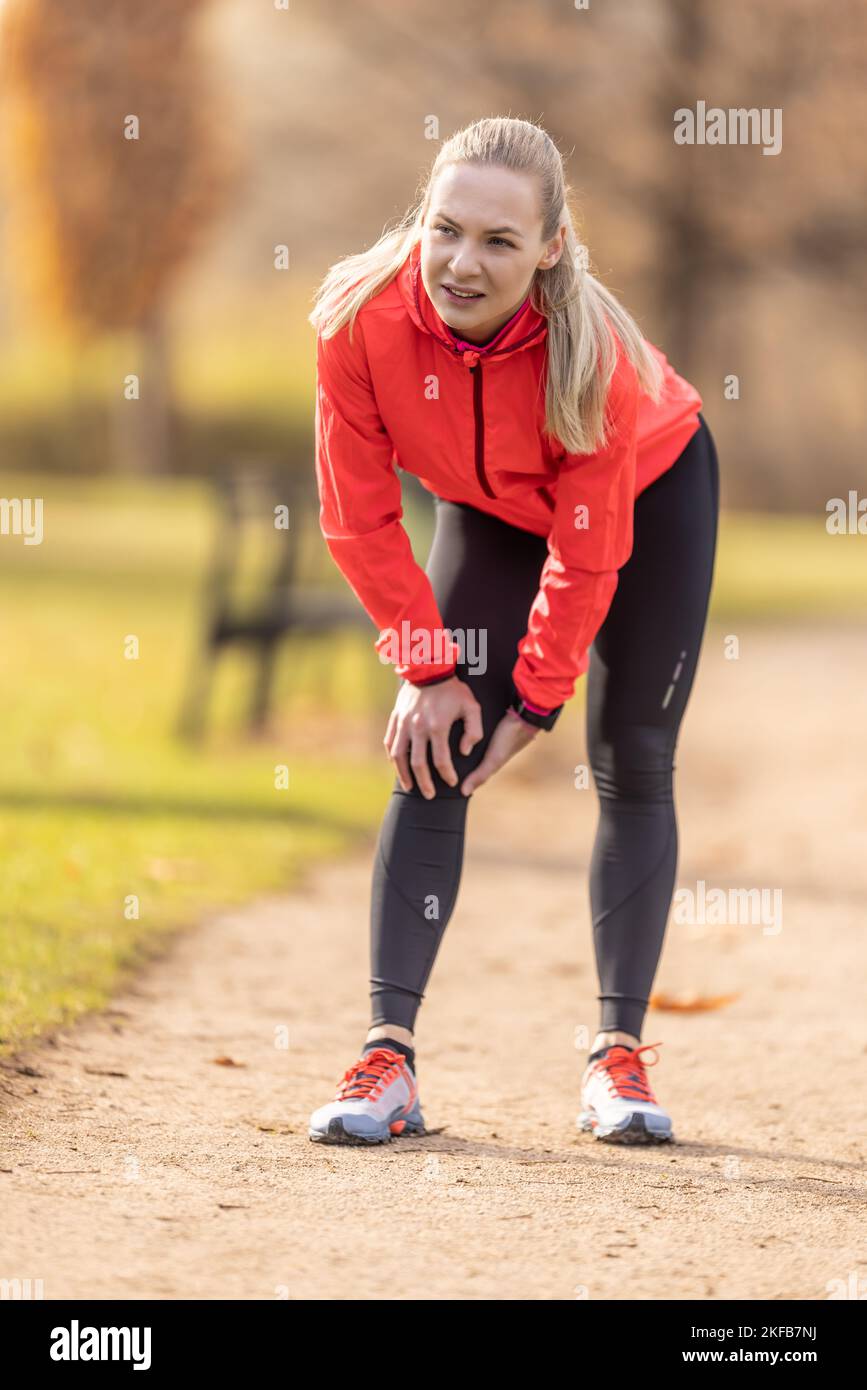 A young athlete sprained her knee while running, she holds it in pain