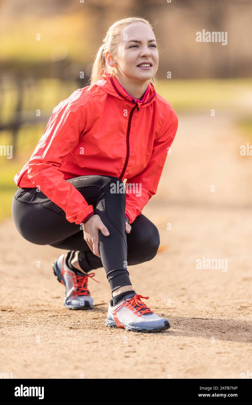 A young athlete sprained her calf while running, she holds it in pain
