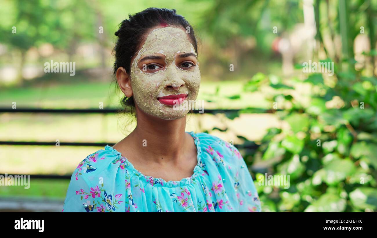 Beautiful young woman using homemade facial mask on face and relaxing at Home. Asian women with Multani Mitti and Rose Water face pack. Portrait of sp Stock Photo