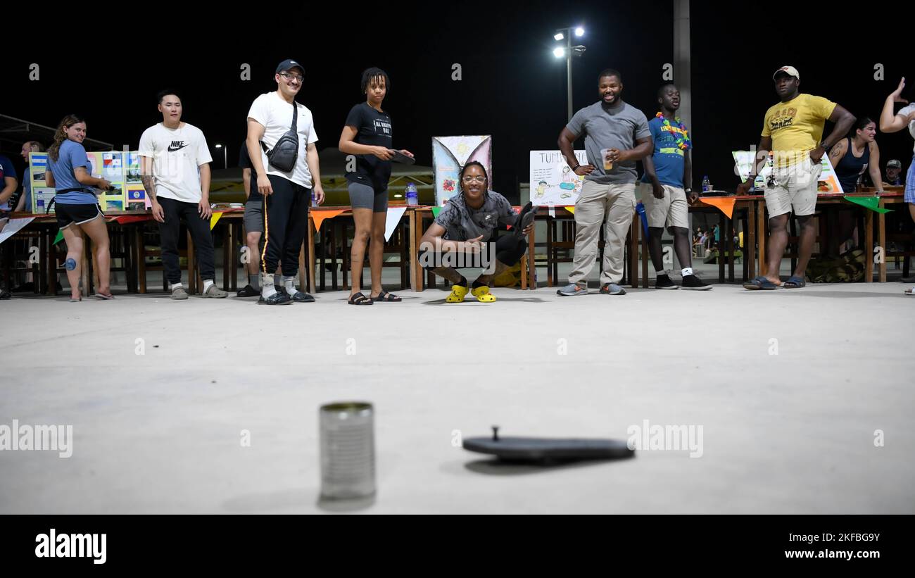 Airmen from the 380th Air Expeditionary Wing learn to play the game “Tumbang Preso” during International Heritage Night, September 2, 2022, at Al Dhafra Air Base, United Arab Emirates. Tumbang Preso, or “Knock Down the Prisoner,” is a traditional Filipino children’s game that involves throwing a slipper at a bottle or can while another player guards the target. Stock Photo