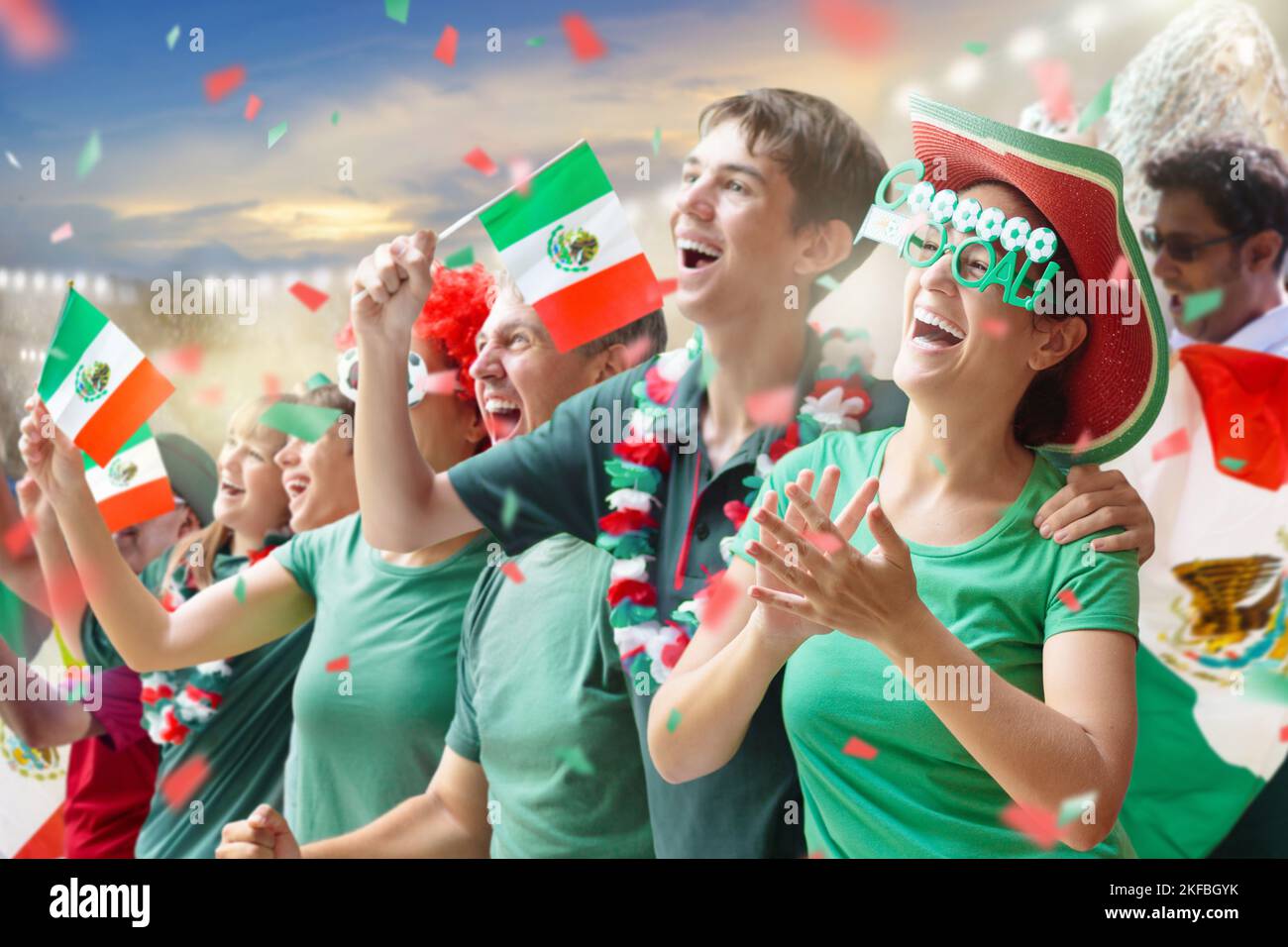 Mexico football supporter on stadium. Mexican fans on soccer pitch watching team play. Group of supporters with flag and national jersey Stock Photo