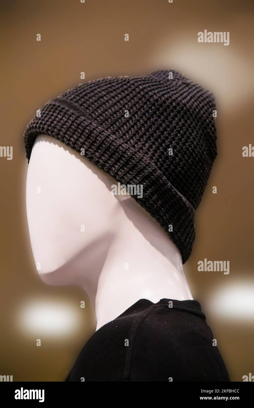 Featureless mannequin head side view with dark stocking cap and