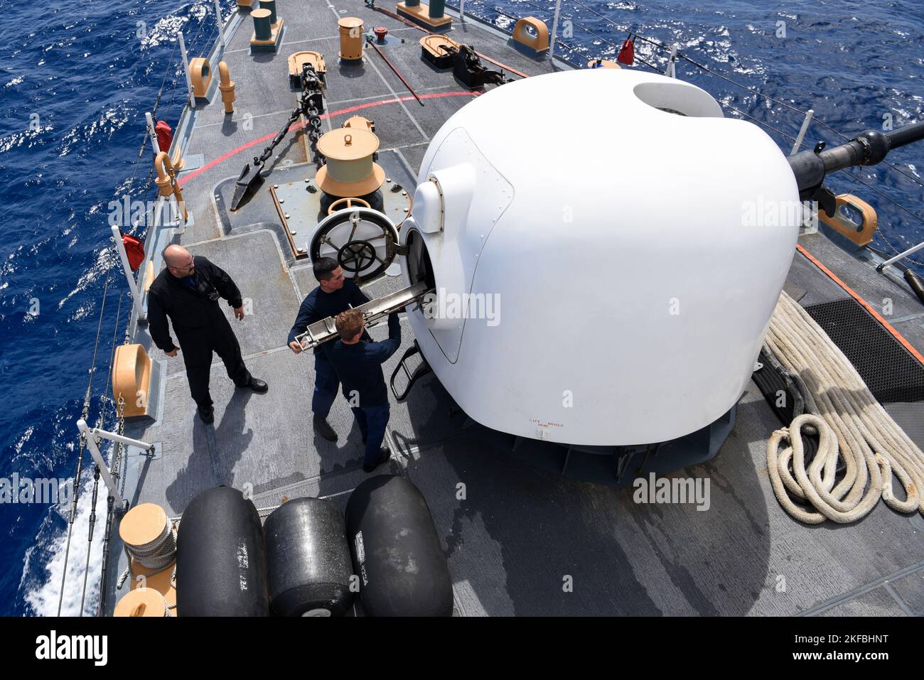 (Left to right) U.S. Coast Guard Chief Petty Officer Craig Horrighs, Seaman Santiago Jauregui, and Ensign Seth Anderson download the MK-75 gun on the USCGC Mohawk (WMEC 913) while underway in the Atlantic Ocean, Sept. 2, 2022. Mohawk is on a scheduled deployment in the U.S. Naval Forces Africa area of operations, employed by U.S. Sixth Fleet to defend U.S., allied, and partner interests. Stock Photo