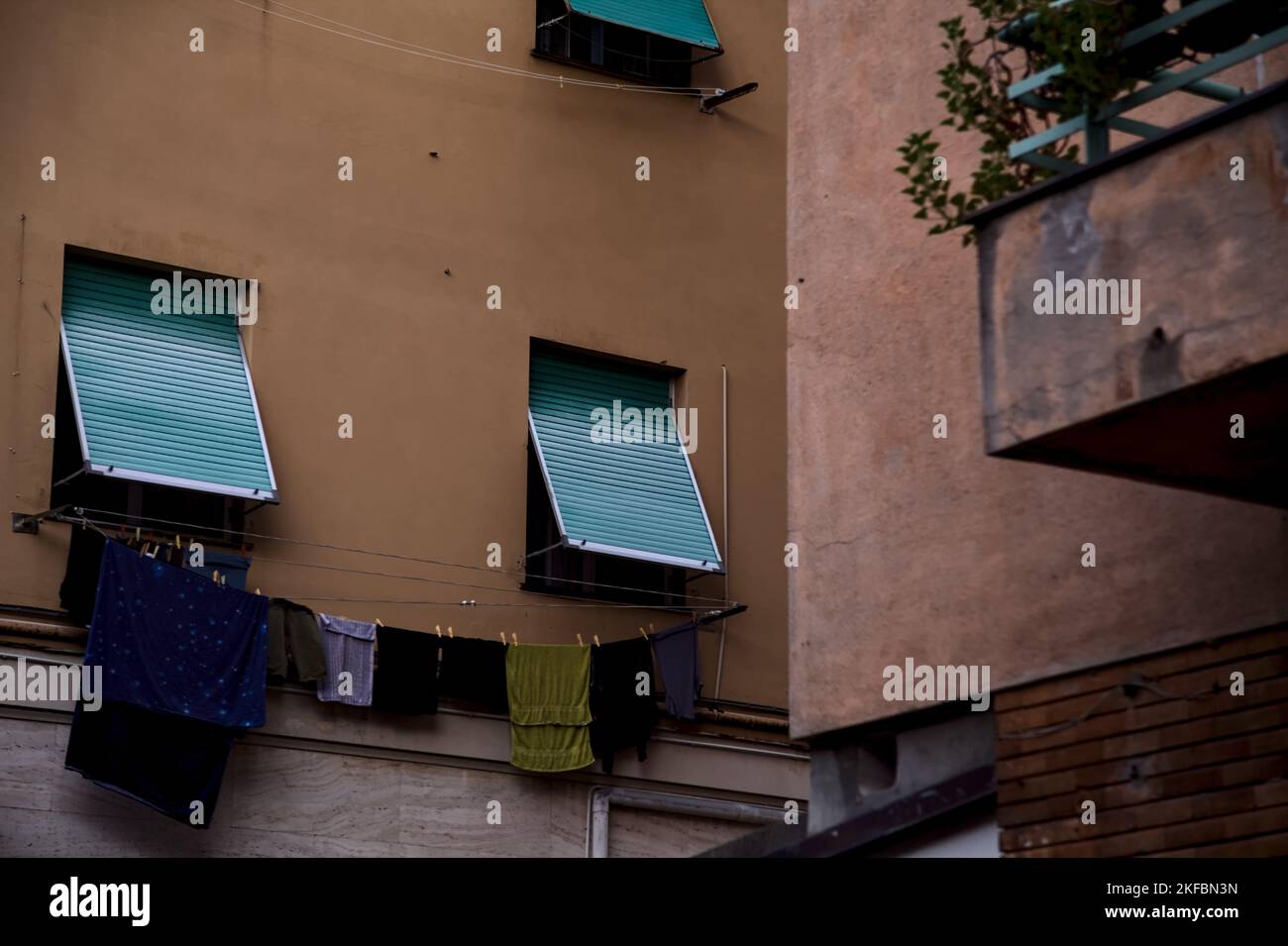 Windows  closed by curtains and clothes hanging on a facade of a condominium Stock Photo
