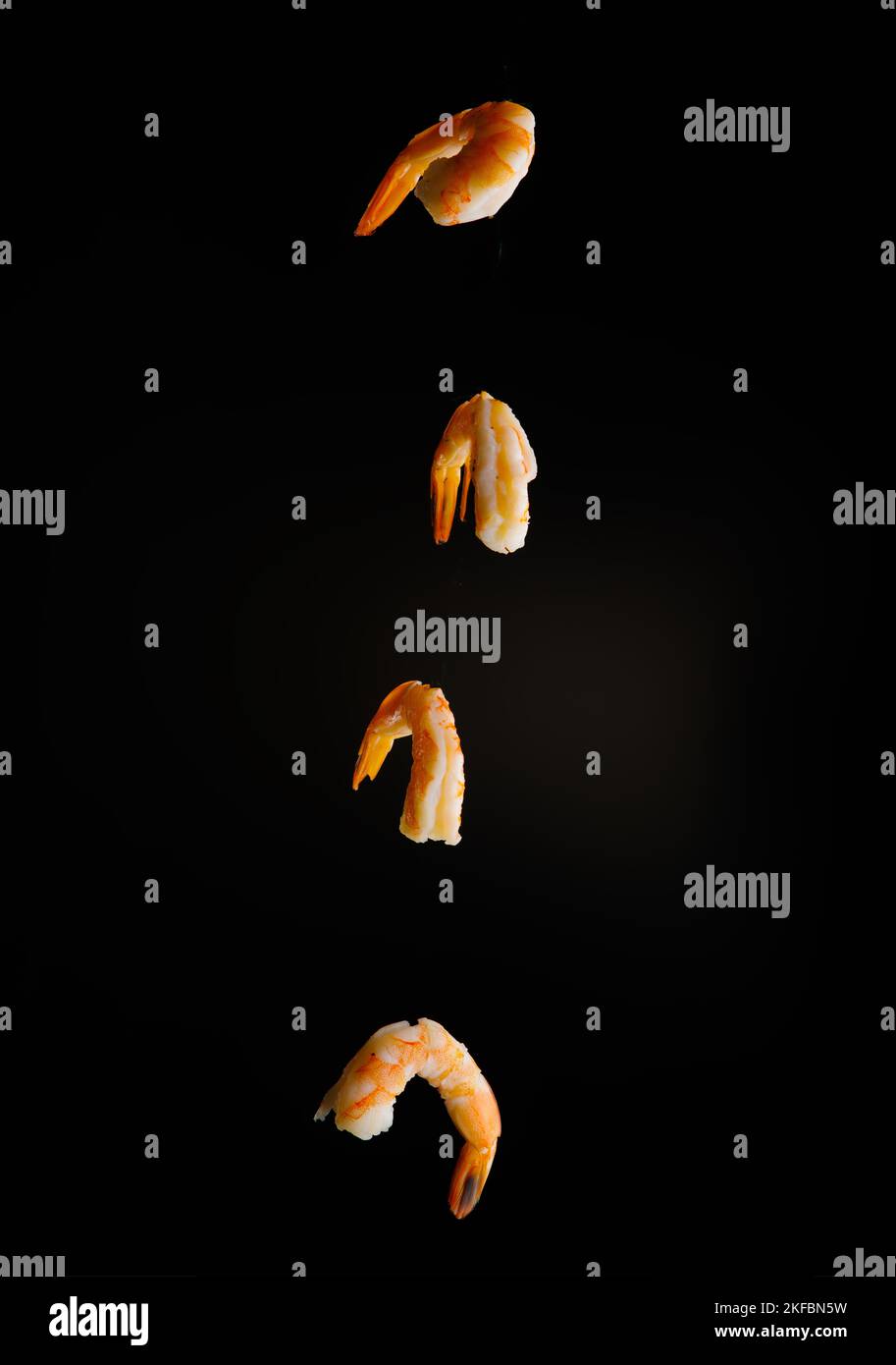 Appetizing orange shrimps in the frozen flight on a black background. Product ready to use. Healthy food, vitamins, proteins. Recipe book, food blog. Stock Photo